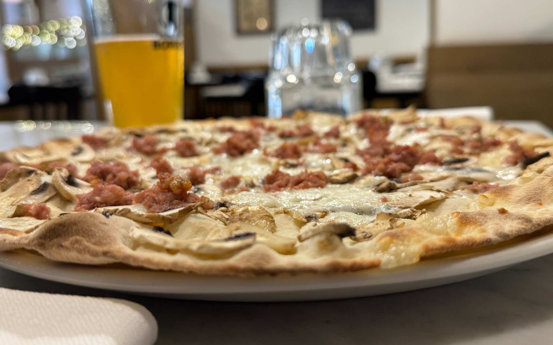 Large round pizza with beer